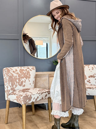 Model looking over her shoulder in the Long Cool Woman hooded waffle jacket in copper and brown mineral wash, side view