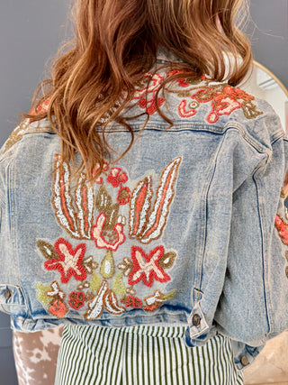 Front pocket and beaded sleeve detail on medium wash denim jacket