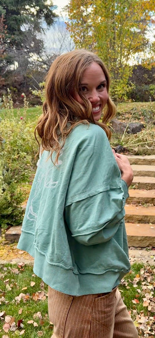 Side view of the Unbroken Moose hoodie showing the relaxed fit and dropped shoulders